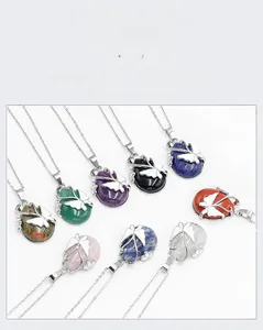 Various teardrop natural crystal pendants with silver butterfly accents on white background