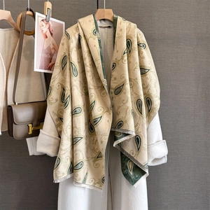 Châle en simili-cachemire à motif cachemire avec franges sur un manteau blanc