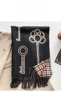 Close-up of double-sided jacquard scarf featuring vintage key pattern and long tassels