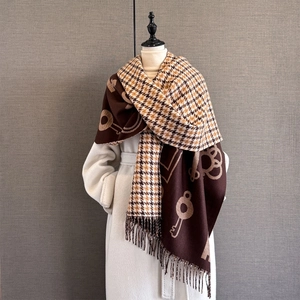 Detail of vintage key pattern and houndstooth texture on thick fringed scarf