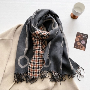 Close-up of thick retro houndstooth scarf with fringes styled on a beige coat