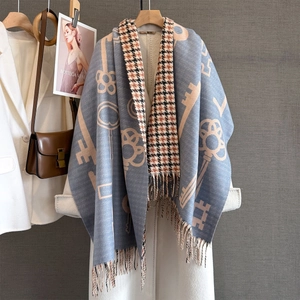 Detail showing the gray-blue cashmere-like scarf with key patterns and fringe edge