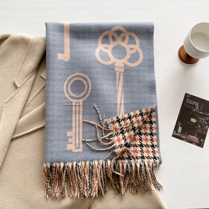 Detail view of double-sided jacquard scarf featuring key patterns and fringe edge