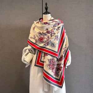 Detail of vintage floral butterfly shawl with red borders and fringe on white coat