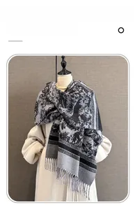 Close-up of imitation cashmere scarf featuring retro ink patterns and grey tassel details