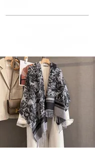 Detail view of soft cashmere-like scarf with black and white ink pattern and fringes