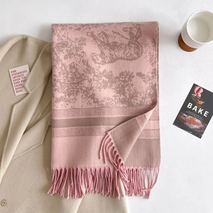 Detail of pink cashmere-like scarf showing luxury horse carriage jacquard and fringe edges