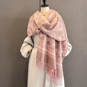 Close-up of vintage jacquard pattern and long tassels on a thick autumn winter shawl