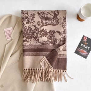 Detail of beige cashmere-feel scarf with brown vintage jacquard pattern and long tassels