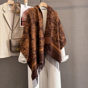 Detail of dark brown jacquard knit shawl with vintage texture and long tassel fringes