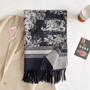 Detail view of thick knitted scarf with jacquard texture and long fringe tassels