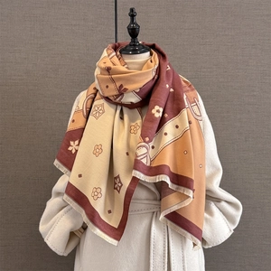 Detail of jacquard scarf showing vintage floral patterns and fringe edge on wool coat