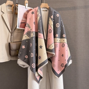 Detail of multi-color jacquard scarf with floral heart pattern and fringe on white coat