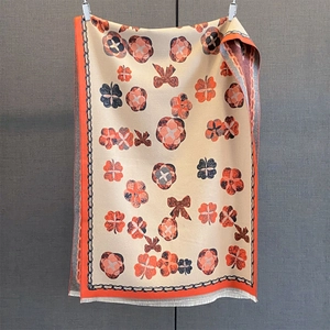 Détail de l'écharpe à motif floral et nœud avec des finitions à franges blanches