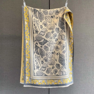 Detailed view of marine life pattern and fine fringe edge on soft yellow shawl