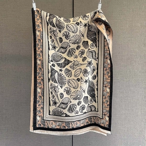 Detail of cashmere-feel scarf featuring seashell prints and fine tassel edge craftsmanship