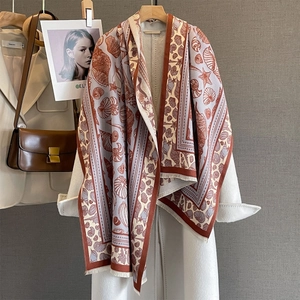 Detail of seashell and starfish print on warm brick red scarf with frayed edges