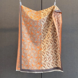 Détail du pashmina à motif paisley avec contraste orange et beige et douces franges