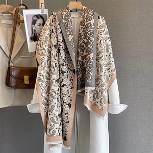 Écharpe style cachemire à motif paisley et franges sur un manteau en laine