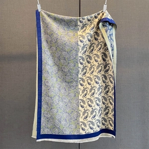 Détail du motif jacquard cachemire sur une écharpe douce avec de fines franges blanches