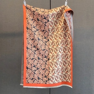 Détail de l'écharpe en jacquard cachemire à motifs paisley avec bordure orange et franges