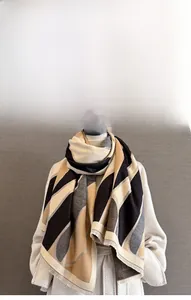 Detail of geometric color-block scarf showing thick cashmere-like texture and fringes
