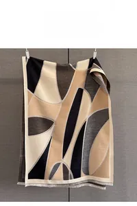 Detail of fine jacquard weave and short fringe on geometric earth tone winter shawl