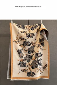 Detail of floral jacquard knit scarf showing soft texture and fine fringe trim