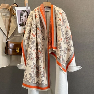 Close-up of floral bird print scarf with orange borders and soft short fringe details