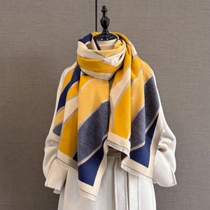 Detail of geometric color-block scarf featuring fine tassels on thick cashmere-like fabric
