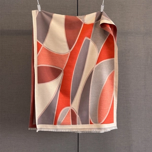 Macro view of geometric color-block scarf featuring orange and beige cashmere-like texture