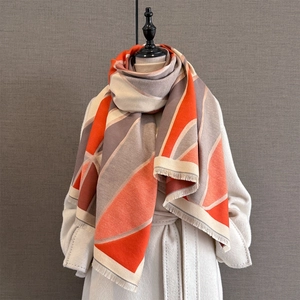 Detail of soft thick scarf featuring geometric color blocks and fringe tassels