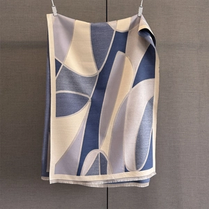 Detailed view of the soft abstract geometric pattern and tassels on a thick winter scarf