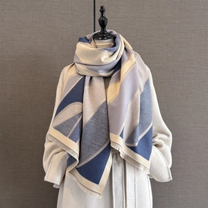 Artistic geometric color block cashmere-like scarf with fringe on a white coat model