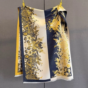 Detail of sunflower jacquard pattern on navy and yellow cashmere feel scarf with tassels
