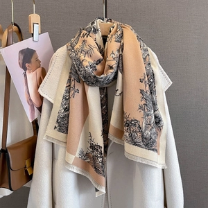 Detail of vintage floral print scarf with tassel edge styled on a white wool coat