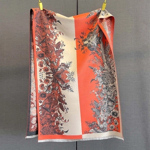 Detail of vintage floral pattern on orange and beige scarf with fine white fringes