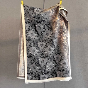 Detail of vintage floral swirl print on black and beige scarf with fine fringe edges