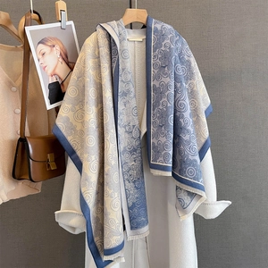 Retro paisley print scarf in blue and beige with tassels on white wool coat