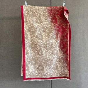 Detailed shot of red and gold floral mandala shawl with delicate white fringe tassels