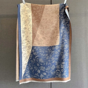 Detail of color-block scarf featuring floral paisley prints and delicate white fringes