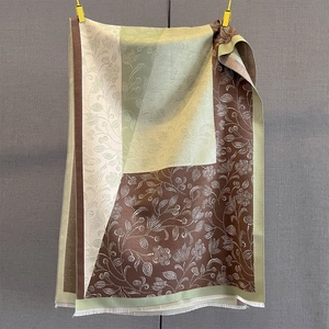 Close-up of color-block paisley scarf with detailed floral patterns and fringe edges