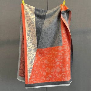 Detailed view of color-block paisley pattern and delicate white fringe on warm shawl