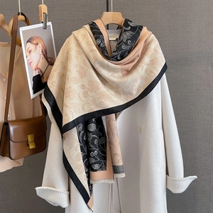 Detail of autumn paisley print scarf with color-block design and soft tassel edges