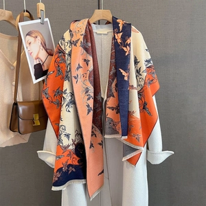 Dettaglio di sciarpa in maglia morbida con motivo jacquard a farfalla e frange