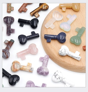 Close-up of heart-shaped natural gemstone key carvings on a wooden display tray