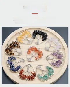 Detail of handcrafted heart-shaped life tree pendants with natural crystal stones