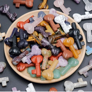 Macro shot of assorted natural crystal heart-shaped key carvings in a wooden tray