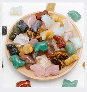 Detailed macro view of assorted hand-carved crystal and agate hippo figurines on a wood tray