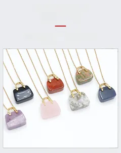 Macro detail of mini handbag-shaped natural crystal pendants in seven vibrant colors